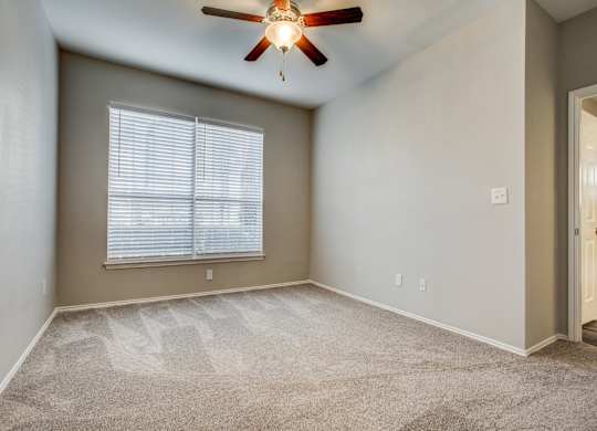 Apartments for Rent in Plano TX - Carrington Park - Bedroom with Carpeting, Beige Walls, and Large Window