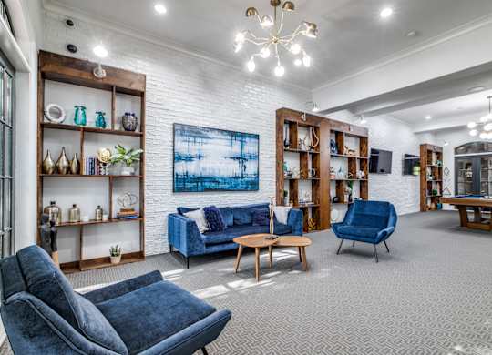 A living room with a blue sofa and grey carpet.