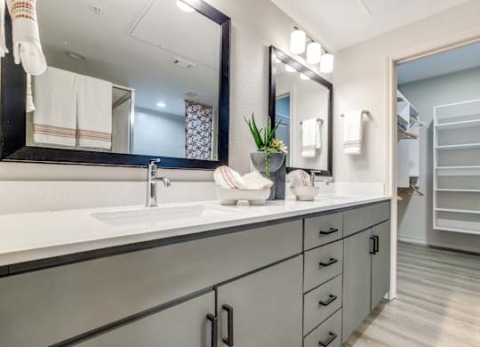 A bathroom with a sink, mirror, and towel rack.