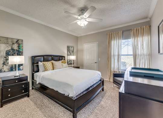 a bedroom with a large bed and a ceiling fan