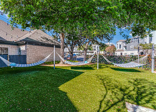 a yard with hammocks in the yard of a house