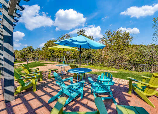 a group of colorful chairs and umbrellas on a patio