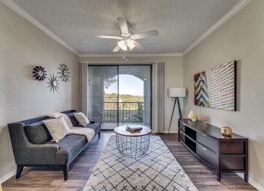 a living room with a couch and a ceiling fan