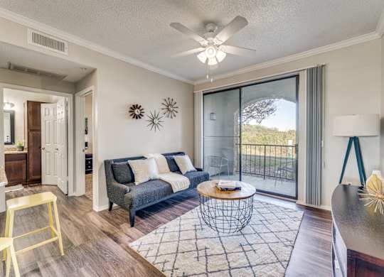an open living room with a sliding glass door to a balcony