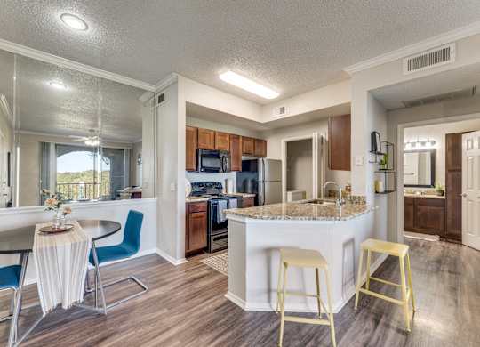 a kitchen with a breakfast bar and a table with chairs