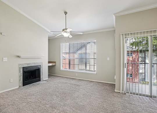 A living room with a fireplace and a ceiling fan.