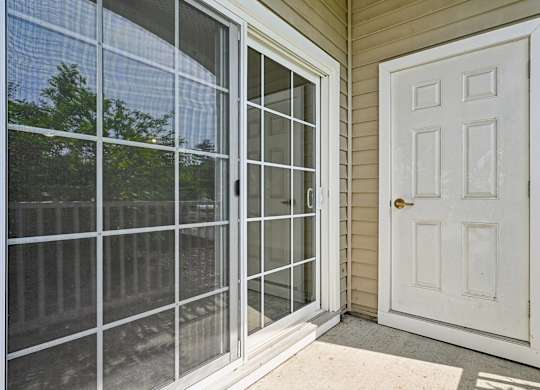 A white door is on the right of a sliding glass door.