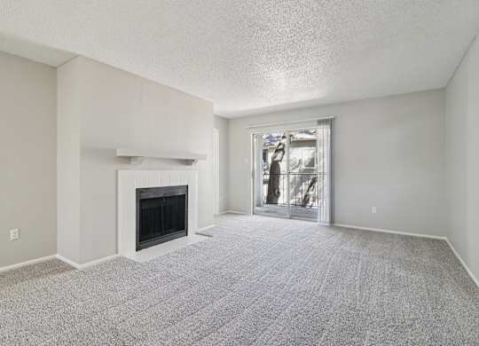A room with a fireplace and a carpeted floor.