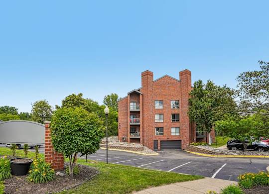 A red brick building with a parking lot in front.