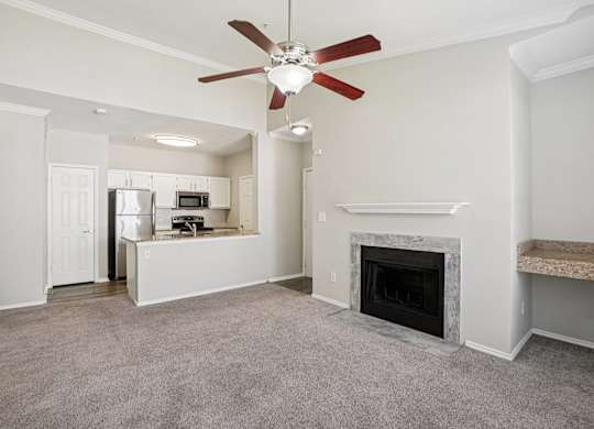 A living room with a fireplace and a ceiling fan.