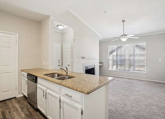 A kitchen with white cabinets and a granite countertop.