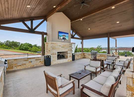A patio with a fireplace and chairs.