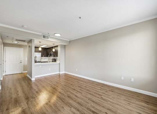 A large empty room with wooden floors and white walls.