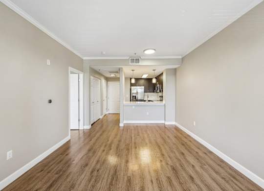 A long, empty hallway with wood floors and white walls.