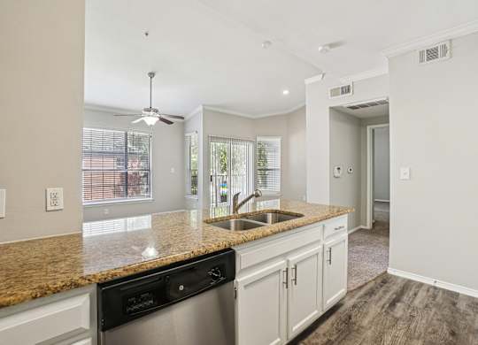 A kitchen with a granite countertop and stainless steel appliances.