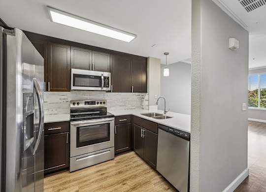 A modern kitchen with stainless steel appliances and wooden cabinets.