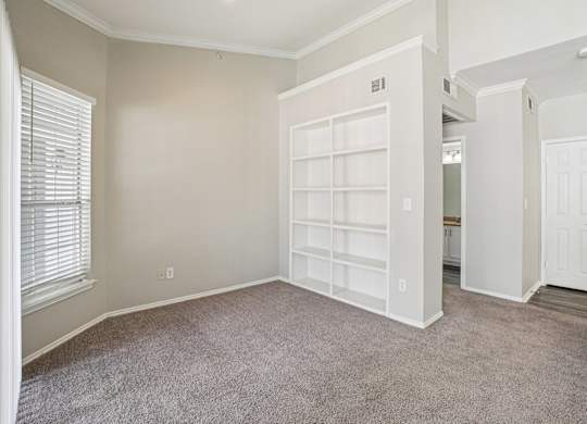 A room with a white door and a window with blinds.