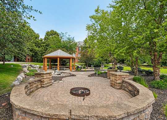 A gazebo is surrounded by a circular brick patio.
