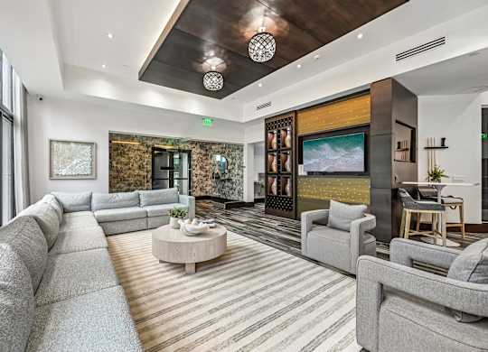 A modern living room with a grey sofa set and a wooden coffee table.
