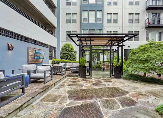 A patio with a stone floor and a pergola.
