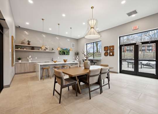 the gathering room and kitchen of a home with a dining table and chairs