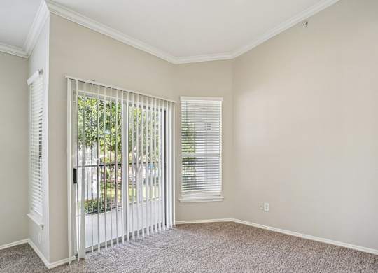 A room with a sliding glass door and a carpeted floor.