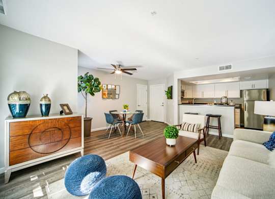 A modern living room with a dining area and kitchen in the background.