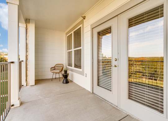 a porch with two doors and a chair on it