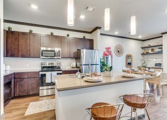 a kitchen with a bar and a dining area with chairs