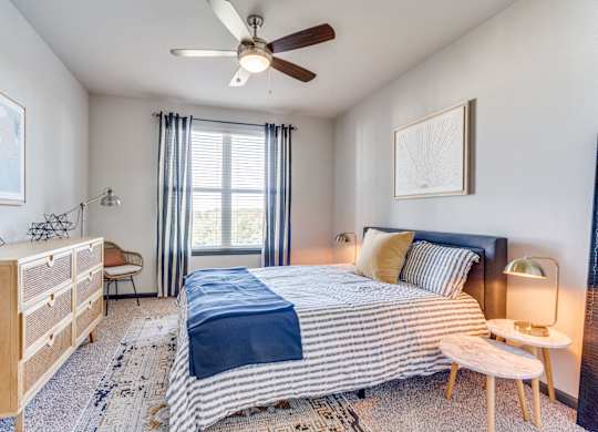 a bedroom with a bed and a ceiling fan