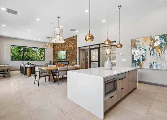 A modern kitchen with a white island and a dining table with chairs.