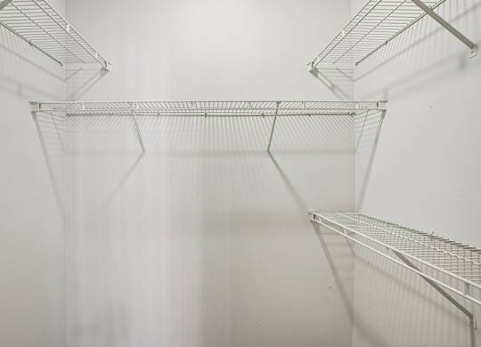 Empty wire shelves in a white room.