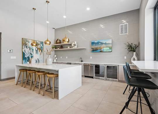 A modern kitchen with a white island and bar stools.