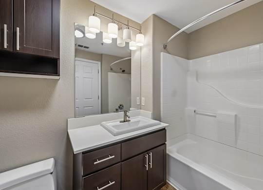 A bathroom with a white sink and a white bathtub.