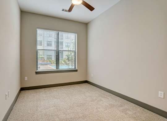 Pet-Friendly Apartments in Nashville, TN- Octave Apartments-  Bedroom with plush carpet and a ceiling fan