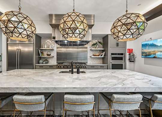 A modern kitchen with a marble table and chairs.