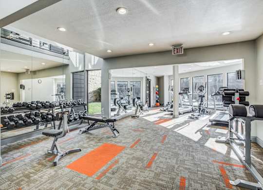 A gym with orange mats on the floor.