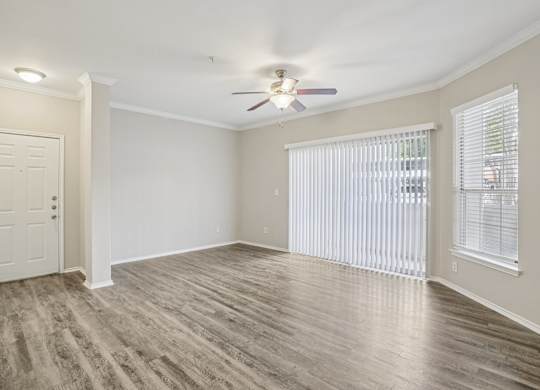 A room with a ceiling fan and a door.