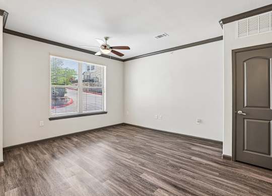 A room with a ceiling fan and a door.