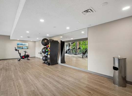 A room with a wooden floor and a mirror on the wall.