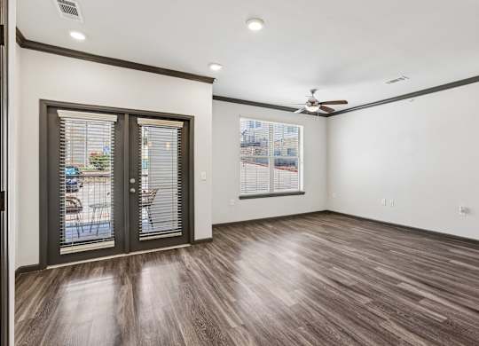 A room with a sliding glass door and a ceiling fan.