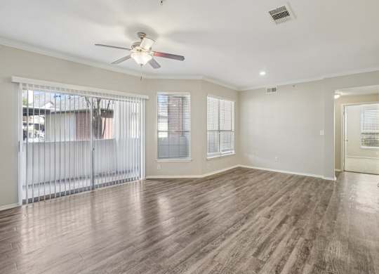 A room with wooden floors and a ceiling fan.