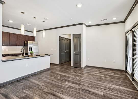 A kitchen with a white counter and brown wood flooring.