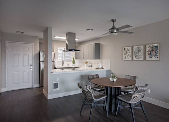 A modern kitchen with a dining table set for four.