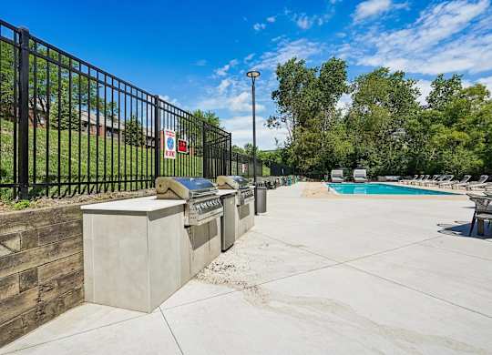 A pool area with a black fence and a concrete structure.
