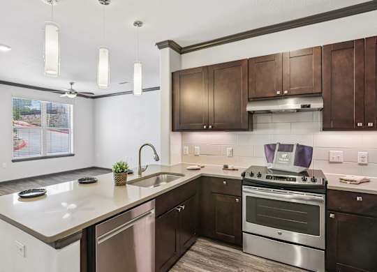 A modern kitchen with dark wood cabinets and stainless steel appliances.