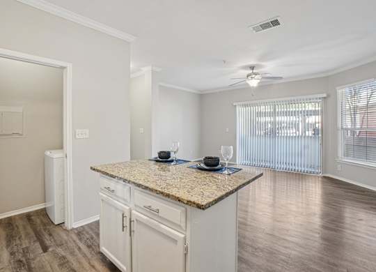 A kitchen with granite countertops and white cabinets.