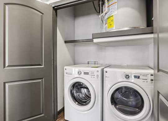 Two white front load washing machines in a laundry room.