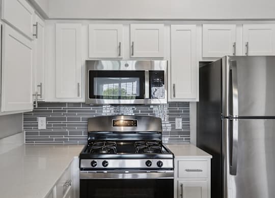 A modern kitchen with a stove and refrigerator.