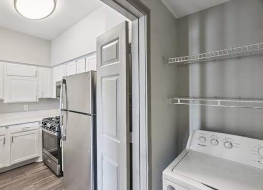 A white kitchen with a refrigerator, oven, and dishwasher.